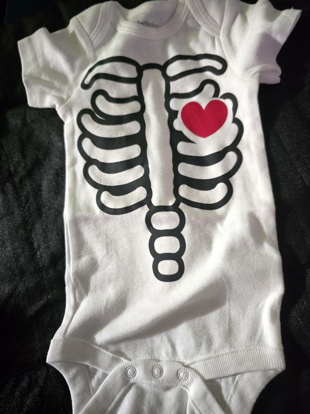 White Baby Onesie with Black Ribcage and Red Heart